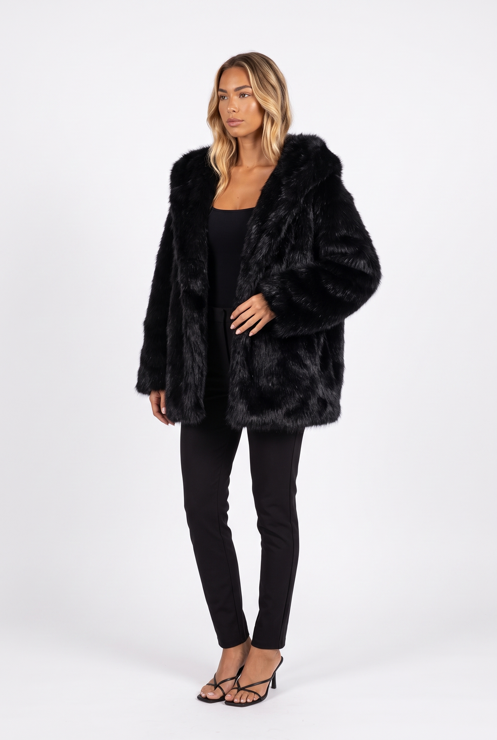 Oversized shaggy faux fur hooded coat in black — three-quarter